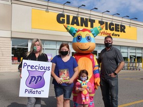 Charlene Renaud, left, creator of the Precious Piñata Children's Educational Toy & Book, is offering it for sale at the Giant Tiger store in Chatham thanks to franchise owner Mark Lush, right. They were joined or the store launch on Sept. 18 by Savannah Gainsford, 11, and Sydney Danis, 5, along with the Precious Piñata mascot. Ellwood Shreve/News/Postmedia Network