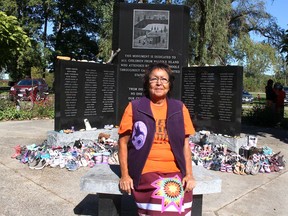 Residential school survivor Beverly Williams sits in front of a monument dedicated to all children from the Walpole Island First Nation who attended residential schools in Canada and the United States. Ellwood Shreve/Chatham Daily News/Postmedia Network