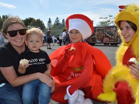 From left, mom Breanne Van Moorsel holds Gabe, 2, who enjoys an apple and new friends: Emily Swerdfeger, dressed as an apple, and Sierra Latulippe, dressed as a chicken, at the Iroquois Apple Festival on Saturday September 18, 2021 in Iroquois, Ont. Shawna O'Neill/Cornwall Standard-Freeholder/Postmedia Network