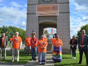 Cornwall City Council members, Chiefs of Akwesasne, knowledge keepers, representatives of the Catholic District School Board of Eastern Ontario and representatives of the Indigenous Education Advisory Committee stand under a banner on the clock tower and in front of a flag that were raised at Lamoureux Park honour of Orange Shirt Day on Tuesday September 28, 2021 in Cornwall, Ont. Shawna O'Neill/Cornwall Standard-Freeholder/Postmedia Network