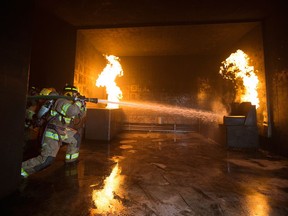 Participants in Camp Inspire battle a fire during a training scenario in Edmonton on Sept. 19, 2021. Camp Inspire is a firefighting camp for women and gender diverse communities, hosted by Edmonton Fire Rescue Services.
