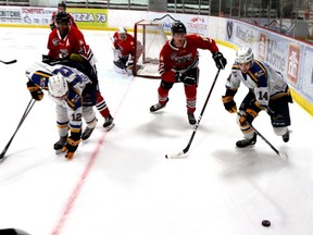 Alex Dominique and Tanner Komzak tried to make their way to the puck for the Wolverines before the Oil Barons could. Brad Quarin/Postmedia Network