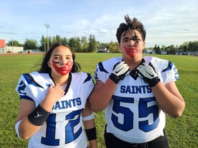 Alicia Gladue (left) is the only girl to play on the Saints football team in Fort McMurray. At a practice, she has a red handprint over her face to acknowledge MMIW. Supplied image
