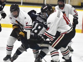 Owen Hodgkins (2) and Zach Dow (10) of the Mitchell Hawks sandwich Sam Barry of the Woodstock Navy Vets in front of the Hawks' net during third period exhibition action Sept. 11 at the Mitchell & District Arena. The hometown Hawks won 6-4, avenging a 5-3 loss one night earlier. The Hawks took to the road this past weekend in Tavistock and Wellesley to conclude their pre-season. ANDY BADER/MITCHELL ADVOCATE