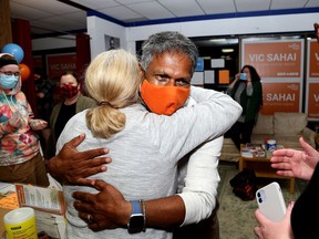 Kingston and the Islands New Democratic Party candidate Vic Sahai hugs office manager Christina Crausen at his party's headquarters in Kingston during federal election night on Monday.