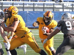 Rasheed Tucker of the Queen's Gaels protects the ball as he runs for yardage against the Ottawa Gee-Gees during Ontario University Athletics football action at Richardson Stadium in Kingston on Saturday, Sept. 25, 2021. Queen's won the game, 30-7.
