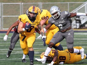 Konner Burtenshaw of the Queen's Gaels runs for yardage against James Peter of the Ottawa Gee-Gees during Ontario University Athletics football action at Richardson Stadium in Kingston on Saturday, Sept. 25, 2021. Queen's won the game, 30-7.