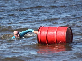 Bob McLaughlin reaches out to touch the barrel and end his 2021 Kiwanis Ottawa River Swim.