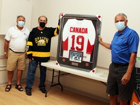 Bill Richardson (centre) has donated an autographed Paul Henderson Team Canada replica jersey from the 1972 Summit Series to the Pembroke Legion for a fundraising auction. Thanking him for the donation are Branch 72 president Stan Halliday and sports committee chairman Denis Levasseur. Bids for the jersey close Oct. 16.