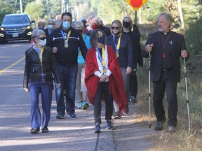 Virtual Camino de Santiago pilgrimage participants from St. John's Black Bay mark the end of the respective journeys by finally taking part in a walk together near the church. Leading the group is Pastor Albert Romkema, right.