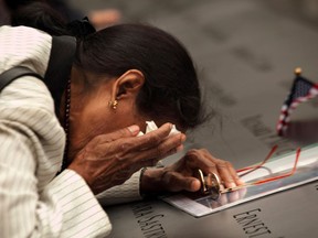 Vasantha Velamuri mourns at the memorial pool at the sight of her husband's name, Sankara Sastry Velamuri, who died in the World Trade Center during the 9/11 attacks, during the dedication ceremony for the 9/11 National Memorial and ceremonies for the 10th anniversary of the attacks at the World Trade Center site in New York, U.S., September 11, 2011. Carolyn Cole/Pool via REUTERS/File Photo