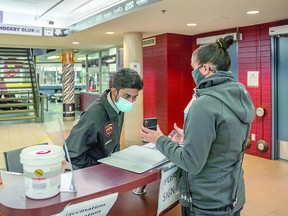 ACTION AT JOHN RHODES: North East Regional Security Services officer Mihir Shah checks patrons for vaccination proof at the John Rhodes Community Centre as they enter for various events. The mandatory proof of vaccination requirements to attend certain settings and facilities came into effect Sept. 22, throughout Ontario. The Ontario government website indicates that individuals can provide proof of immunization by downloading or printing their vaccine receipt from the provincial booking portal, or by calling the Provincial Vaccine Booking Line at 1-833-943-3900. BOB DAVIES/FOR SAULT THIS WEEK