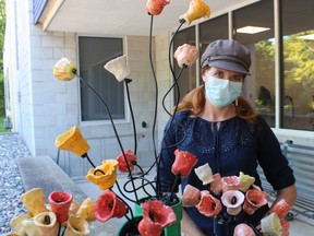 Dana Thorne, curator-supervisor at the Lambton Heritage Museum, stands with  pottery tulips on display as part of this year's Paint Ontario show and sale. It opens Friday and runs to Sept. 26 at the museum in Lambton Shores.