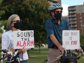 Rose and Paul Stebbins, co-founders of Climate Change Sarnia-Lambton, hold signs during speeches Wednesday at the Centennial Flag Court at the start of a climate change rally and march.