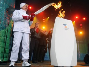 Norma Cox lights a cauldron with the Olympic torch during an event in Sarnia in December 2009. Cox, who supported several projects in the community, died Aug. 30.