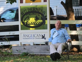 Bob Hailliday sits next to the recently installed pollinator garden before the start of its dedication service Saturday at St. John in the Wilderness Anglican Church in Bright's Grove.