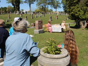 Audience members watch as Carol Graham, left, and Amy Nap, with Petrolia Community Theatre, perform a scene during Saturday's Hillsdale Cemetery Walking Tour.
