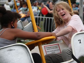 Best friends Alaysia Stephenson, 10, left, and Gillian Cran, 12, enjoy one of the rides at the Forest Fall Fair Sunday. An organizer, volunteer and long-time attendee all said attendance over the weekend was the most  at the fair they'd ever seen. (Tyler Kula/ The Observer)