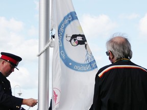 Kettle and Stony Point Coun. Marshall George watches as Sarnia Police Const. and Walpole Island First Nation member Uriah Dodge raises the Kettle and Stony Point flag Saturday at Sarnia's waterfront. Flags for the three First Nations in Sarnia-Lambton were raised at the official opening of the First Nations Flag Plaza. (Tyler Kula/ The Observer)