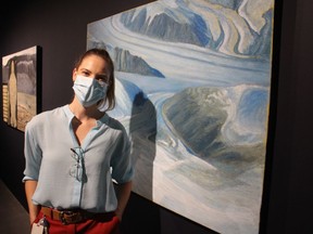 Sonya Blazek, curator of the Judith and Norman Alix Art Gallery stands next to a painting by the late Jean Hay in Facing North, an exhibition opening Friday at the gallery in downtown Sarnia.