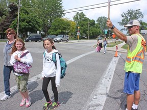 Stoplights and lane reductions are planned for Cathcart Boulevard intersections at Murphy Road and Indian Road. Crossing guard Peter Murphy is pictured in 2014 helping people at Murphy and Cathcart.