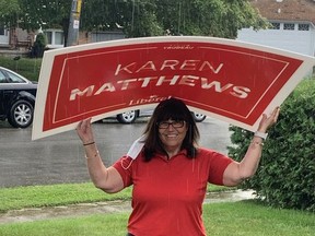 Karen Matthews, the Liberal candidate for Haldimand-Norfolk, takes shelter from the rain with one of her election lawn signs. 
Submitted Photo