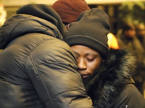 Uche Osagie, right, is comforted by a community member during a candlelight vigil in Sudbury on Jan. 16, 2020, in memory of her three children who died in a collision on New Year's Day.