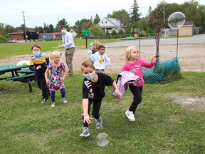 Senior kindergarten students chase after bubbles as part of an outdoor activity at MacLeod Public School in Sudbury, Ont., during the first day back to school on Tuesday September 7, 2021. John Lappa/Sudbury Star/Postmedia Network