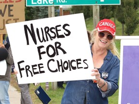 Protesters take part in a rally against vaccine passports and vaccine mandates in workplaces during a rally on Paris Street near Health Sciences North in Sudbury, Ont. on Monday September 13, 2021.