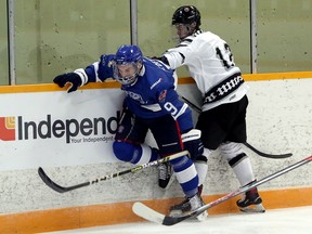 Greater Sudbury Cubs defenceman Carter Geoffroy (9) takes a hit from Espanola Express forward James Eng (13) during first-period NOJHL action at Gerry McCrory Countryside Sports Complex in Sudbury, Ontario on Thursday, September 16, 2021.