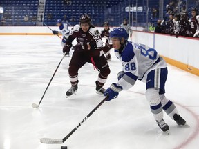 David Goyette, right, of the Sudbury Wolves, looks to pass the puck as Artem Guryev, of the Peterborough Petes, gives chase during OHL exhibition action at the Sudbury Community Arena in Sudbury, Ont. on Friday September 17, 2021. John Lappa/Sudbury Star/Postmedia Network