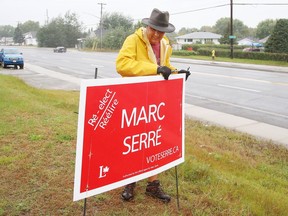 Volunteer Jacques Guy removes an election sign from a lawn in Garson, Ont. on Tuesday September 21, 2021. John Lappa/Sudbury Star/Postmedia Network