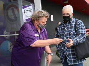 Laurie Larone, left, of Delta Bingo and Gaming in Sudbury, Ont., checks Aime Laroche's vaccination status on Wednesday September 22, 2021. John Lappa/Sudbury Star/Postmedia Network