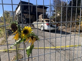 Flowers adorn a fence outside a burnt building on Antwerp Avenue. A female resident was found deceased Tuesday morning after firefighters extinguished a blaze at the multi-unit dwelling. Jim Moodie/Sudbury Star