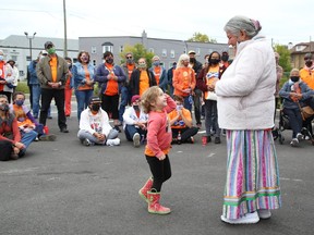 Elder Julie Ozawagosh addresses a crowd as Eleanore Richardson, 3, gets close at a ceremony marking the National Day for Truth and Reconciliation and Orange Shirt Day at the N'Swakamok Native Friendship Centre on Sept. 30.