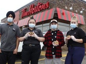 Tim Hortons baker Manjinder Mangat, from left, Ashton Jordan, team member, Audrey Guitard, assistant manager and Brielle Goulet, a Northern College student who was volunteering for the Smile Cookie Campaign at the Tim Hortons in South Porcupine on Tuesday, as the annual campaign which kicked off on Monday will be running until Sunday, Sept. 19, at Tim Hortons all over the country. Locally, the proceedings from this campaign will be going towards the DARE program of Timmins. 

RICHA BHOSALE/The Daily Press