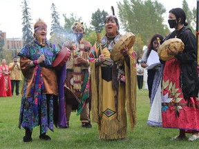 The trio New Moon Singers, from left, Jennie Dundas, Holly Rodrigue and Sarah Rodrigue performed an honour song at the opening of the new Schumacher International Peace Park Tuesday afternoon. Seen standing behind the singers, burning wrapped sweet grass, is traditional dancer George Rose.

RON GRECH/The Daily Press