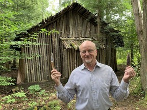 John Benson is raising funds for an in-depth study of the first people to occupy south-central Ontario following the end of the last Ice Age 13,000 years ago. Here, Benson displays flint tools in front of the replica aboriginal longhouse he built on his property north of Marburg. Monte Sonnenberg/Postmedia