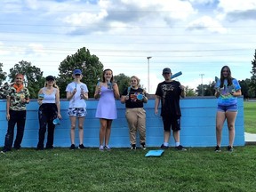 The seven youth artists pose for a group shot after applying the basecoat of blue to the painting area on the Miller Park Skate Park in West Lorne. From left are Emma Deshaw, Destiny Vickers, Taylor Larson, Bree, Karly McCall, Hunter Ooms and Lillian Taylor. Victoria Acres photo