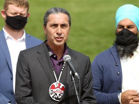 Arlen Dumas, Grand Chief of the Assembly of Manitoba Chiefs, takes the microphone during a media event for federal NDP leader Jagmeet Singh (right) at Oodena Circle at The Forks in Winnipeg on Thurs., Aug. 26, 2021. At left is NDP MP Daniel Blaikie (Elmwood-Transcona). KEVIN KING/Winnipeg Sun/Postmedia Network