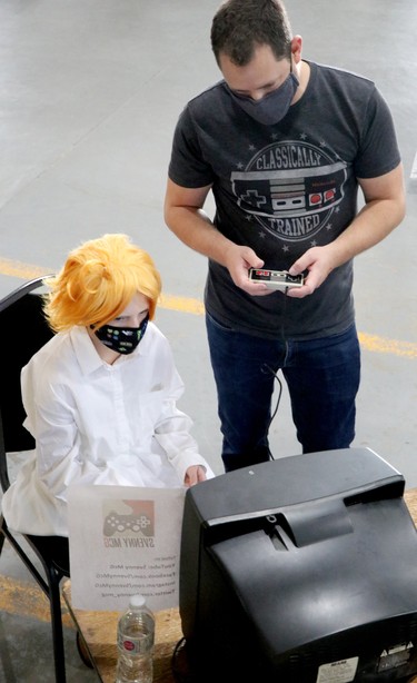 Amelia Reid, as Emma from The Promised Neverland, and her father, Adam Reid, play a video game at Steel City NerdCon at Canadian Bushplane Heritage Centre on Saturday, Oct. 2, 2021 in Sault Ste. Marie, Ont. (BRIAN KELLY/THE SAULT STAR/POSTMEDIA NETWORK)