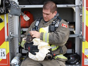Firefighter Trevor Almenar gives a cat oxygen at a fire at a three-unit apartment on Frood Road and Bloor Street in on Monday.