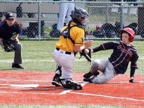 Fourteen-year-old umpire Rheanna Crepeault keeps a close eye on the action at home plate.