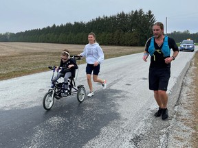 Kevin Owen is shown running with Jackie Lundy and daughter Sydney, a children's treatment centre client, during his recent shore-to-shore marathon fundraiser. (Handout)