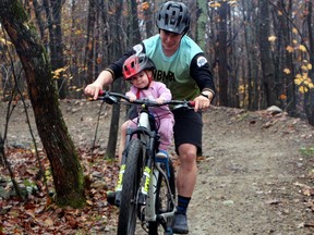 Calliope Murphy, 18 months, enjoys a ride on the North Bay Mountain Bike Association's trail, Saturday, with Travis Murphy.
PJ Wilson/The Nugget