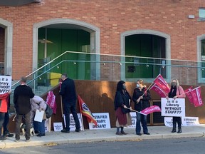 Protesters were picketing outside the Central Branch of the Kingston Frontenac Public Library late Tuesday afternoon, Oct. 19. They were worried about a proposal going before the board of directors on Wednesday that would see the hours at the Pittsburgh Branch extended but without any staff on site.