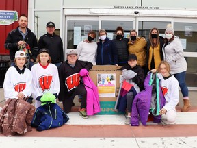 Donations of coats and winter gear are currently being gathered for local families by the Rotary Club and EHA Wolverines. Good Samaritans include (back row, l-r) Joel Cote and Marcus Ryan of the EHA Wolverines; Rotary’s Fay Arcand, Annette Kay, and Candace Laprise; Arni Stephenson’s daughters Kelly Romanchuk and Kathy Johnson; and Rotarian Michelle Robinson; and (front row) the EHA Wolverines players.