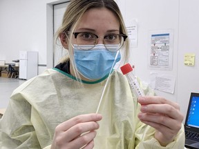 Josie Lamondin, a registered practical nurse, holds up a COVID-19 swab at the assessment centre in Stratford. (Chris Montanini/Stratford Beacon Herald)