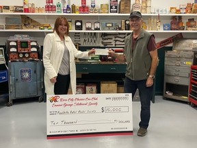 River City Classics Eamon’s Garage Historical Society Vice President Ray Bouillet presents  Foothills Fetal Alcohol Society’s Tracy Cuffe with a $10,000 cheque.