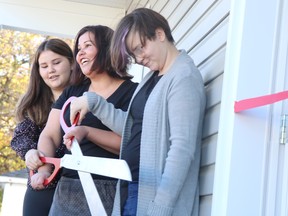Michaela Kyle, 12, Samantha Kyle, and Rylee Kyle, 12, prepare to cut ribbon to their new home built by Habitat for Humanity Sault Ste. Marie & Area on Saturday, Oct. 30, 2021 in Sault Ste. Marie, Ont. (BRIAN KELLY/THE SAULT STAR/POSTMEDIA NETWORK)